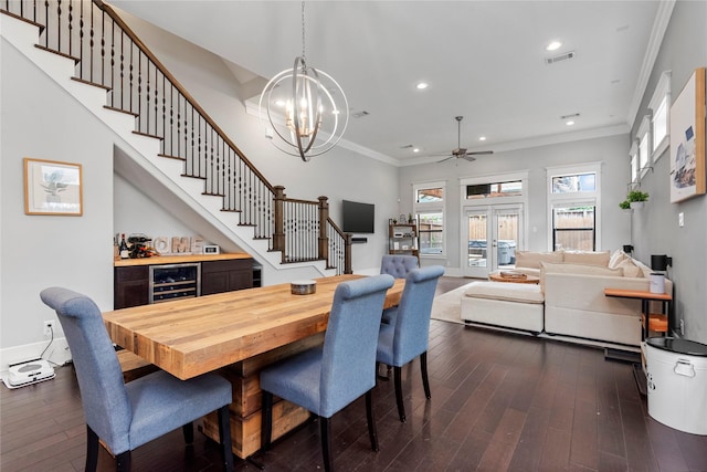 dining area featuring ornamental molding, ceiling fan with notable chandelier, beverage cooler, and dark hardwood / wood-style flooring