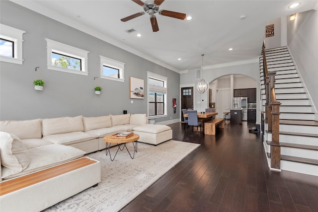 living room featuring dark hardwood / wood-style flooring, ornamental molding, and ceiling fan