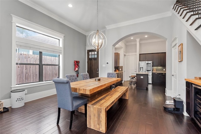 dining room with crown molding, dark wood-type flooring, and an inviting chandelier