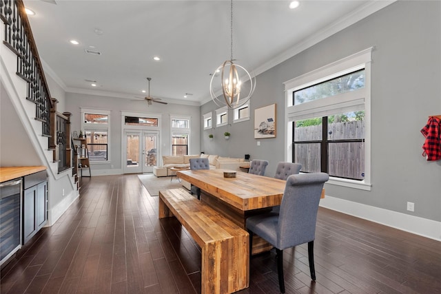 dining room with an inviting chandelier, crown molding, dark wood-type flooring, and french doors