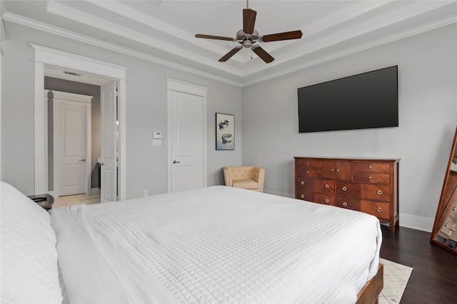 bedroom with crown molding, dark wood-type flooring, a raised ceiling, and ceiling fan