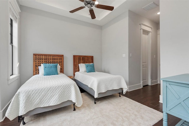 bedroom with multiple windows, dark wood-type flooring, and ceiling fan