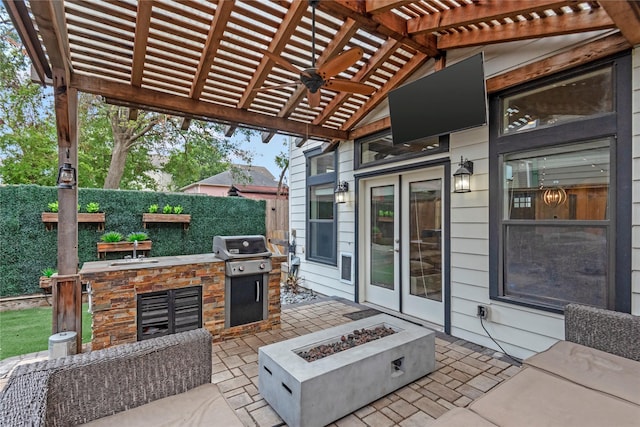 view of patio with sink, area for grilling, a pergola, ceiling fan, and a fire pit