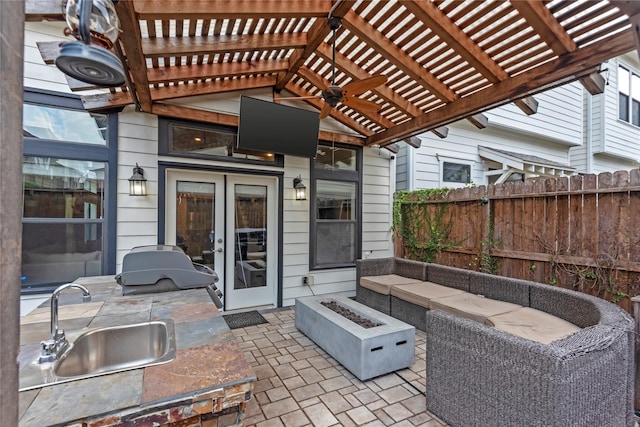 view of patio featuring sink, a fire pit, ceiling fan, a pergola, and french doors