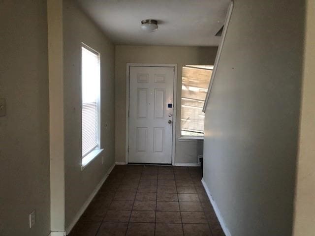 doorway featuring dark tile patterned flooring