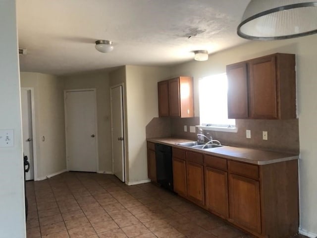 kitchen featuring black dishwasher, sink, backsplash, and light tile patterned floors