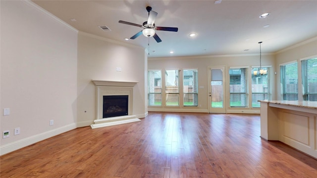 unfurnished living room featuring crown molding, ceiling fan with notable chandelier, light hardwood / wood-style flooring, and a wealth of natural light