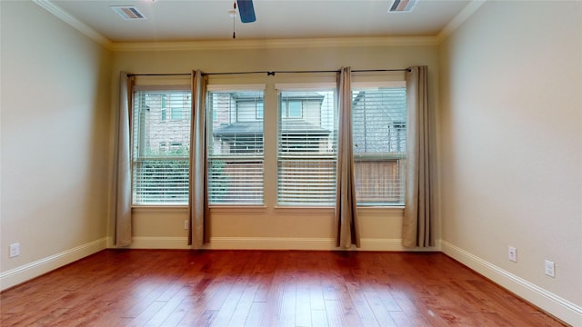 empty room with a wealth of natural light, wood-type flooring, and ceiling fan