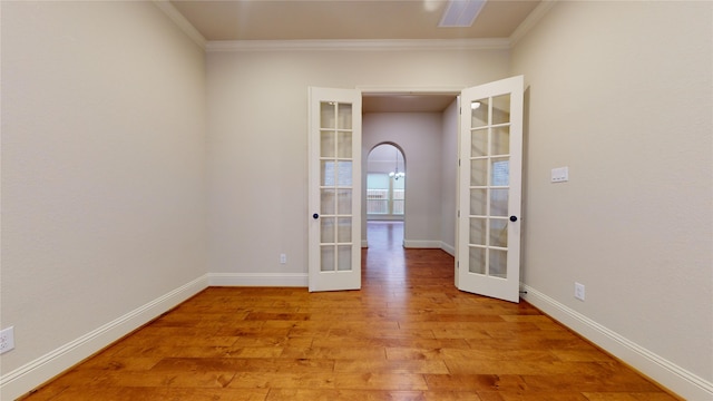 spare room with french doors, ornamental molding, and light hardwood / wood-style floors