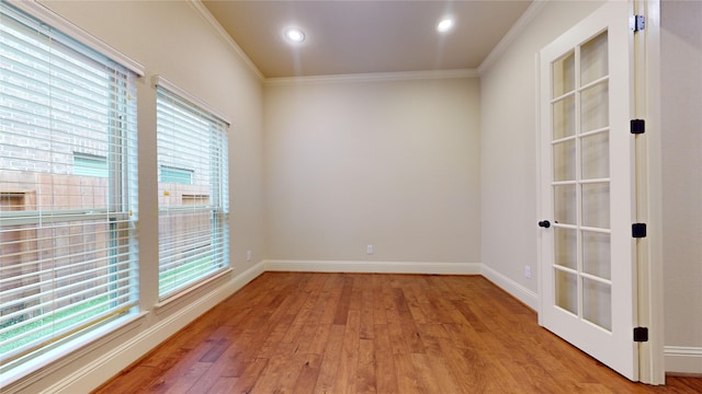 empty room with crown molding and light hardwood / wood-style flooring