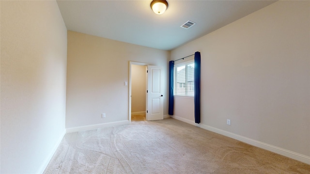 unfurnished room featuring light colored carpet