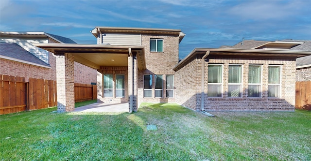 back of property featuring a lawn and a patio area