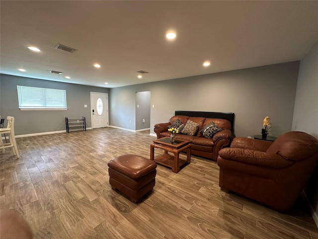 living area featuring recessed lighting, visible vents, light wood-style flooring, and baseboards