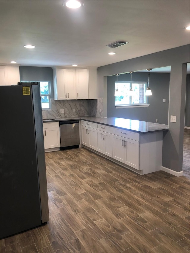 kitchen featuring decorative light fixtures, visible vents, decorative backsplash, appliances with stainless steel finishes, and white cabinets