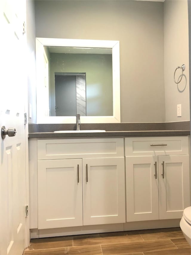 bathroom with wood tiled floor, vanity, and toilet