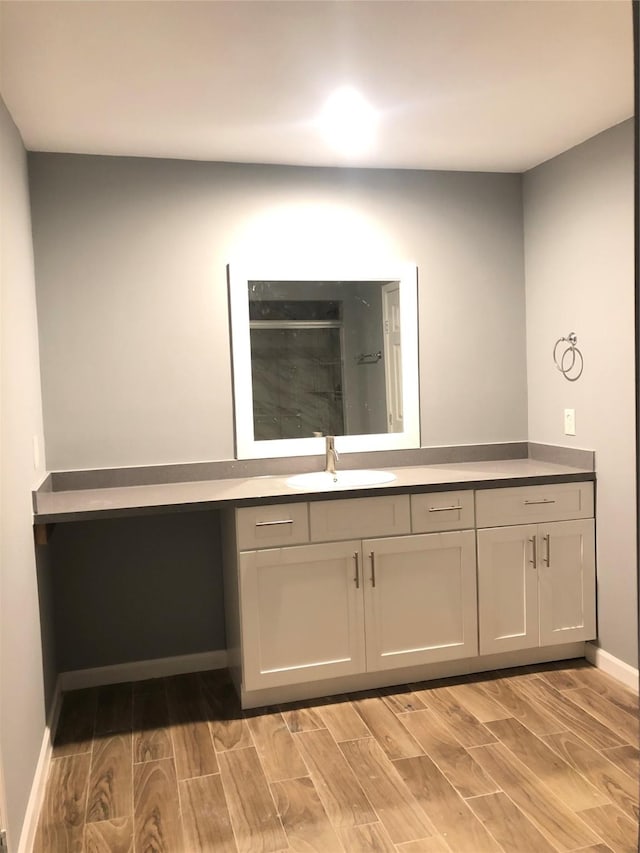 interior space with light wood-type flooring, baseboards, and a sink