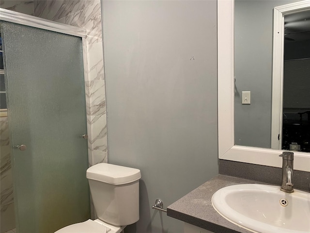 full bathroom featuring an enclosed shower, a sink, and toilet