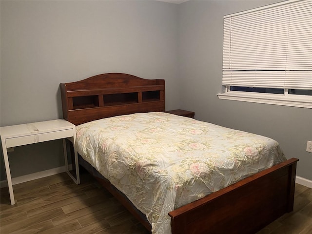 bedroom with baseboards and dark wood-style flooring