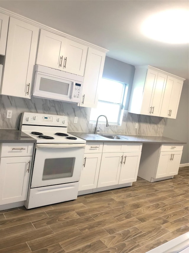 kitchen with white appliances, dark wood-type flooring, a sink, and white cabinetry