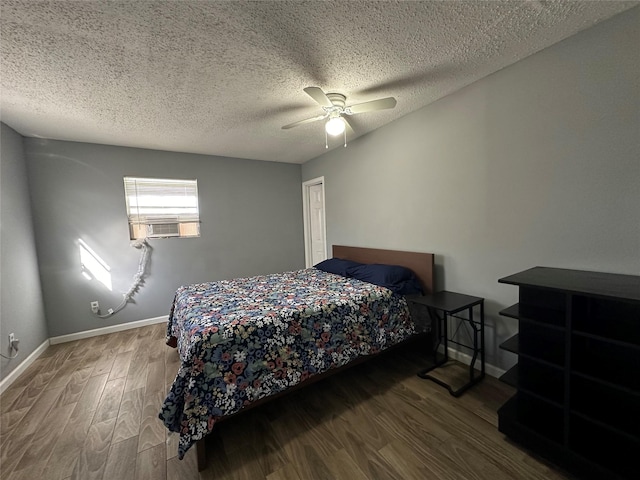 bedroom featuring a textured ceiling, wood finished floors, a ceiling fan, and baseboards