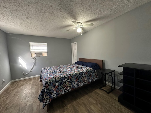 bedroom featuring a textured ceiling, wood finished floors, a ceiling fan, and baseboards