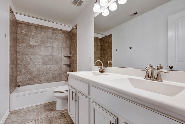 full bathroom featuring tiled shower / bath, tile patterned floors, toilet, and vanity