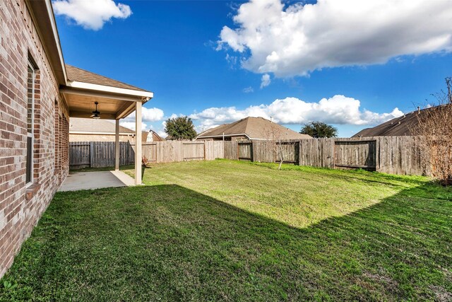 view of yard with ceiling fan and a patio area