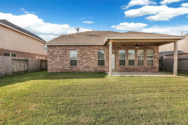 back of house featuring a lawn, ceiling fan, and a patio area