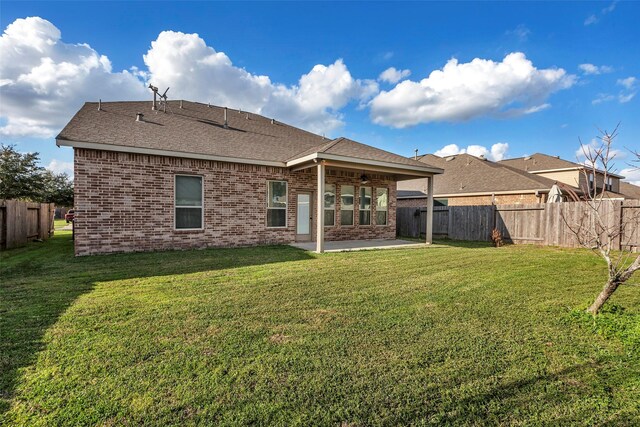 back of house featuring a patio area and a lawn