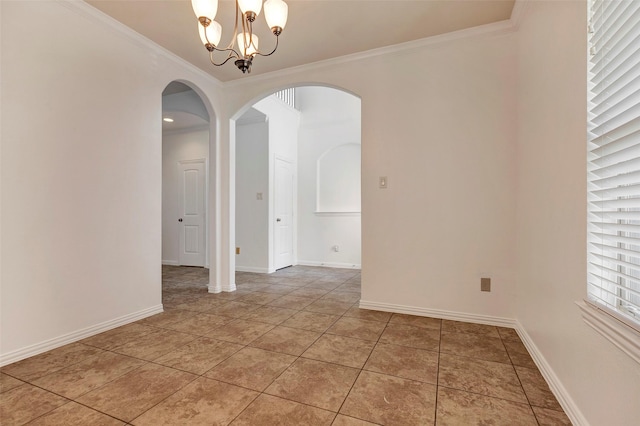 tiled empty room featuring ornamental molding and a chandelier