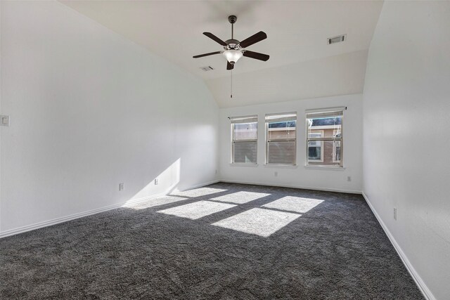 unfurnished room featuring dark carpet, vaulted ceiling, and ceiling fan