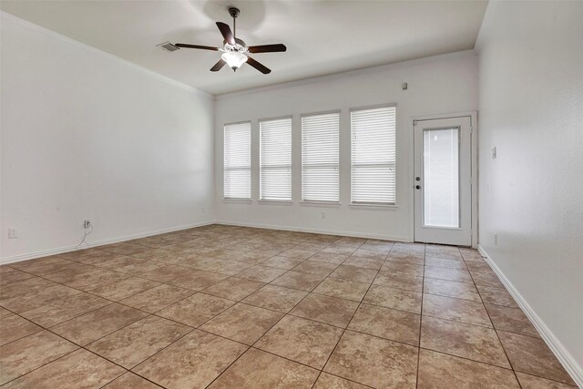 tiled spare room with ornamental molding and ceiling fan