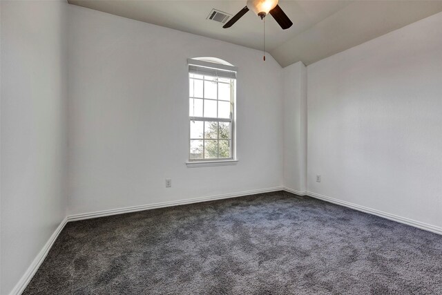 empty room with ceiling fan, lofted ceiling, and dark carpet