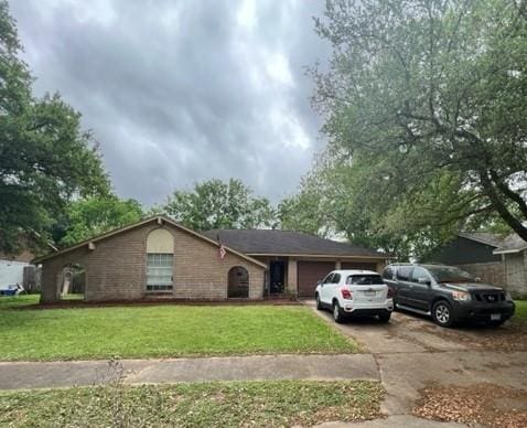 ranch-style house with a garage and a front lawn