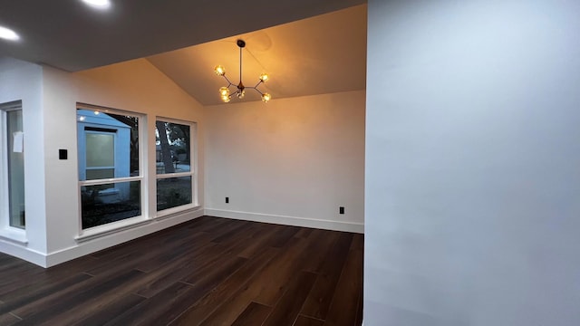 spare room with vaulted ceiling, dark hardwood / wood-style floors, and an inviting chandelier