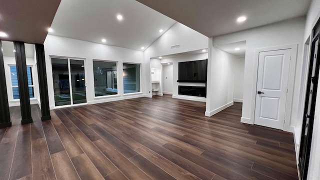 unfurnished living room with vaulted ceiling and dark hardwood / wood-style floors