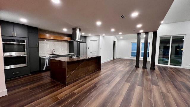 kitchen with a breakfast bar, appliances with stainless steel finishes, dark hardwood / wood-style floors, a kitchen island, and exhaust hood