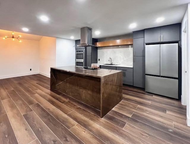 kitchen featuring dark hardwood / wood-style floors, island range hood, stainless steel appliances, and sink