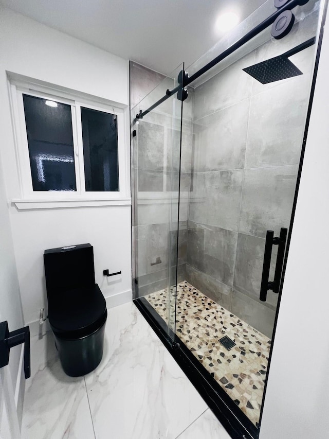 bathroom with toilet and a shower with door