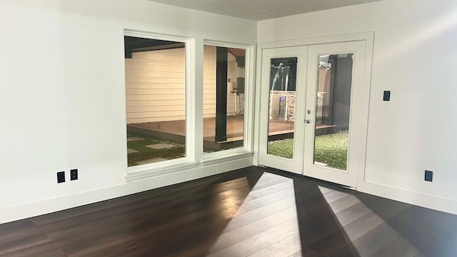 doorway with dark hardwood / wood-style floors, a wealth of natural light, and french doors