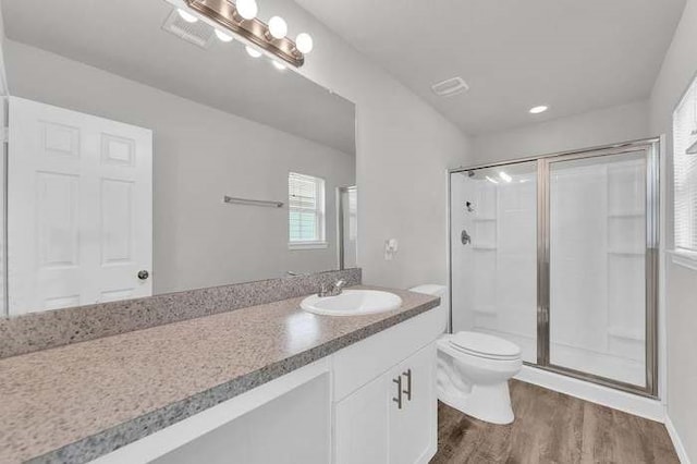 bathroom featuring vanity, hardwood / wood-style floors, an enclosed shower, and toilet