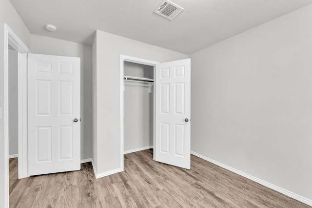 unfurnished bedroom featuring a closet and light wood-type flooring