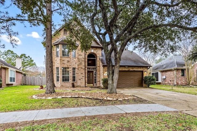 traditional home featuring brick siding, an attached garage, a front yard, fence, and driveway