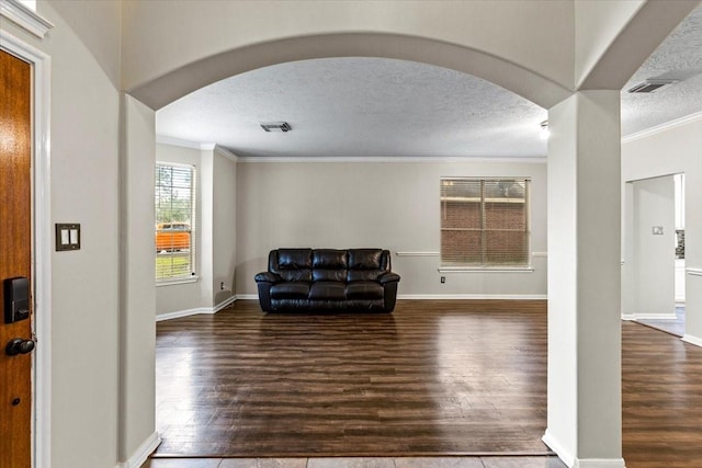 sitting room with arched walkways, a textured ceiling, dark wood finished floors, and visible vents