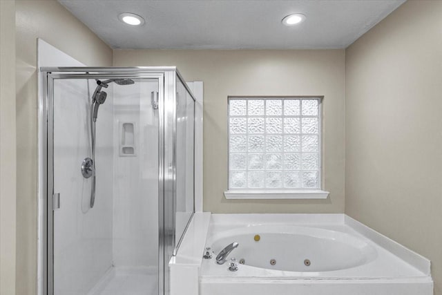 full bath featuring a whirlpool tub, a textured ceiling, a shower stall, and recessed lighting