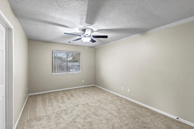 unfurnished room with a ceiling fan, light colored carpet, a textured ceiling, and baseboards