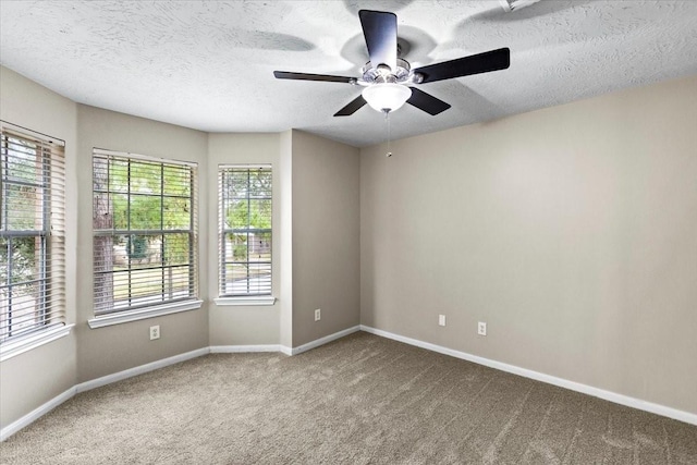 carpeted empty room featuring a textured ceiling and baseboards