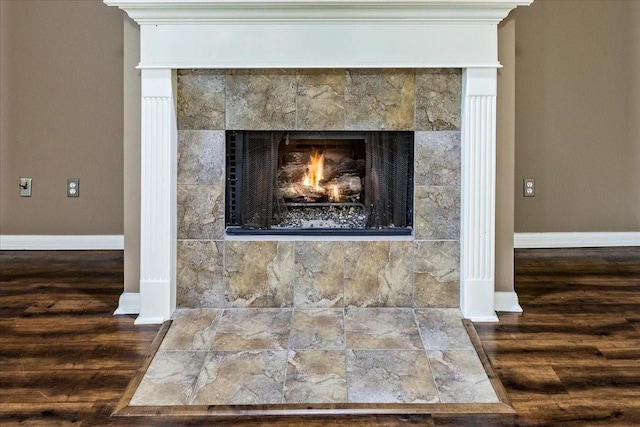 room details featuring a fireplace, wood finished floors, and baseboards