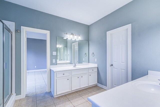 full bathroom with tile patterned flooring, two vanities, and a sink