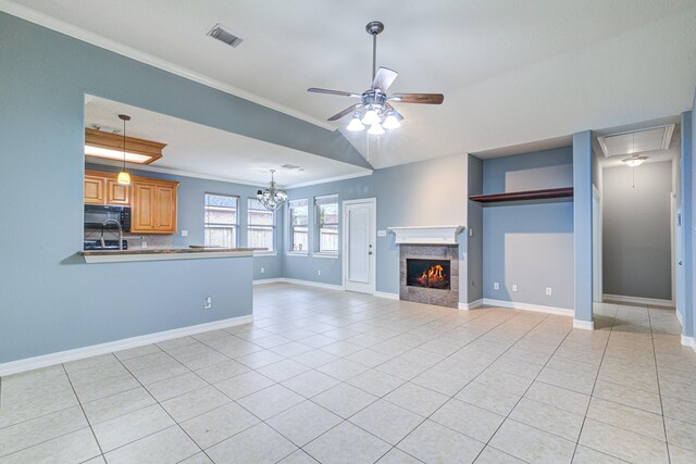 unfurnished living room featuring light tile patterned floors, a tile fireplace, visible vents, and crown molding